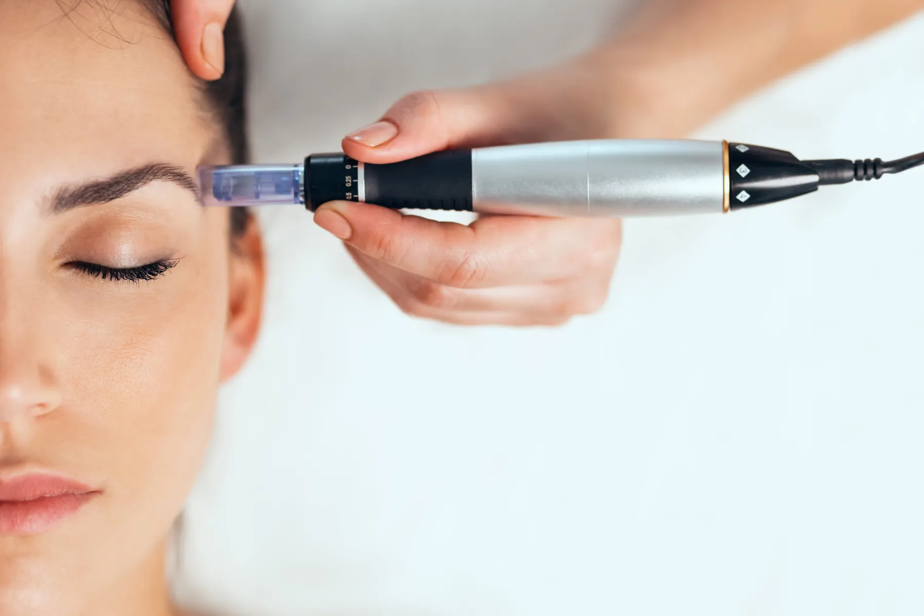 A clinician delivering mesotherapy micro-injections across a client's cheek