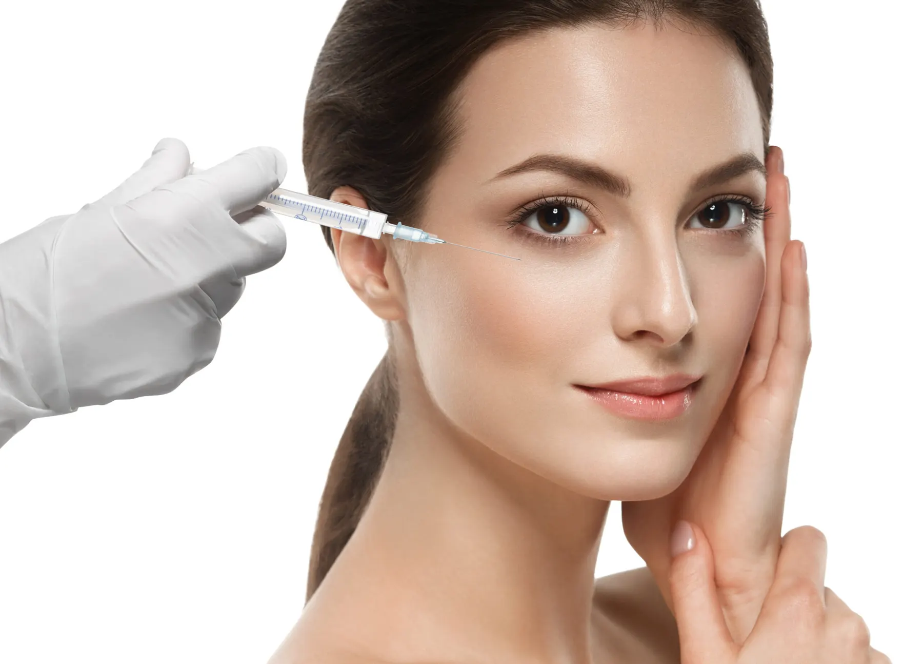 A woman photographed against white while a white-gloved hand holds a fine syringe against her cheek.