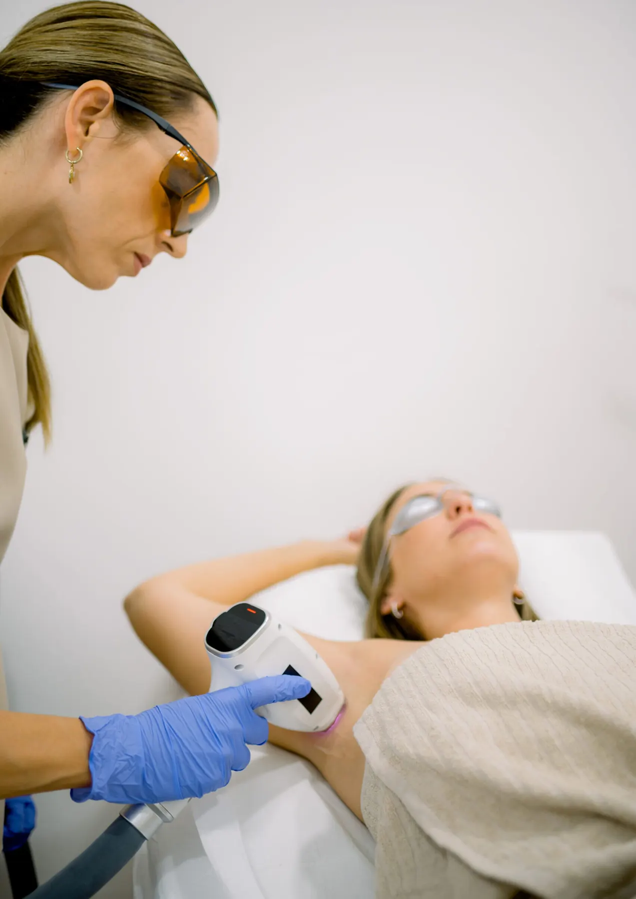 A client receiving laser hair removal treatment on the underarm