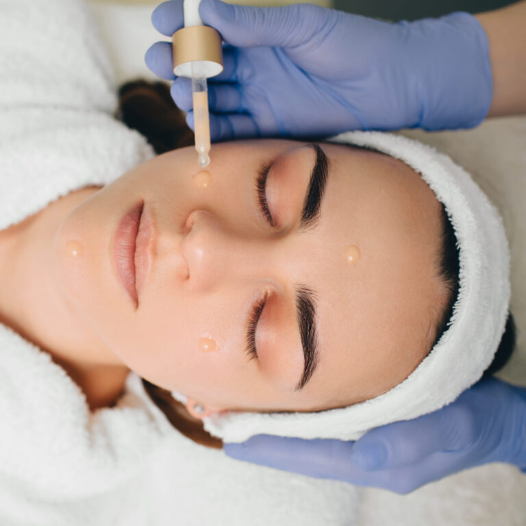 beautician applying serum to female face. Serum treatment skin